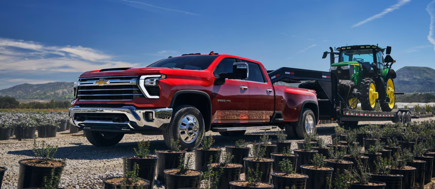2025 Chevrolet Silverado 1500 HD Pulling a Tractor on a trailer